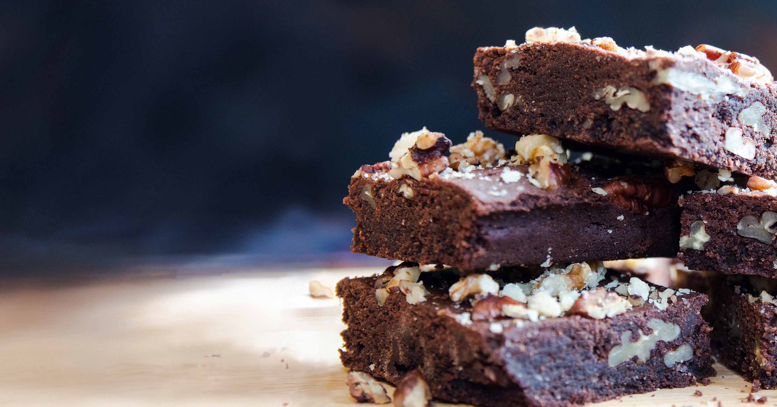 Una pila de brownies de chocolate y nuez, rociados con migas de nuez y nuez triturada, reci&eacute;n sacados del horno